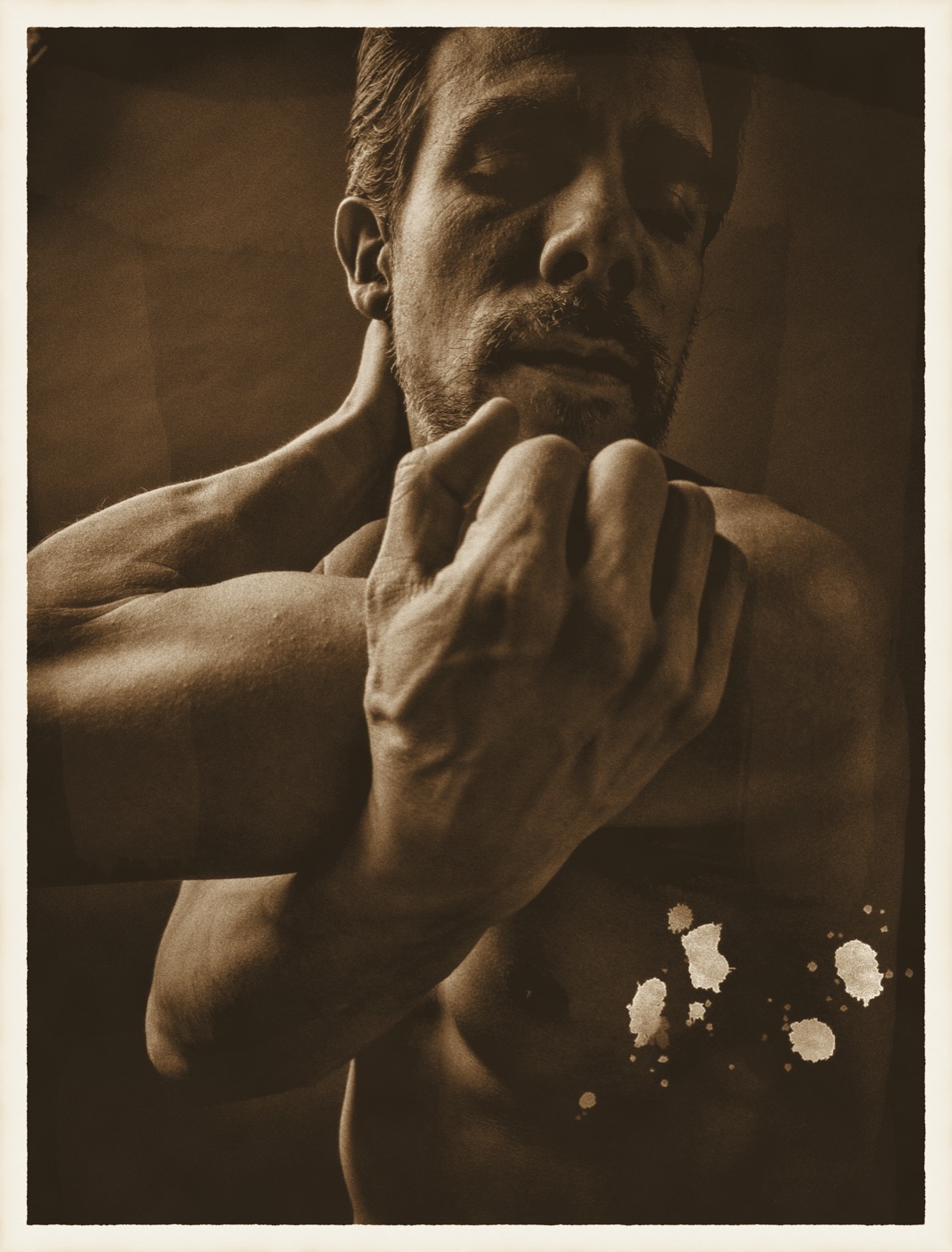 A portrait bleached, rinsed and sepia-toned, with bleach spattered across one corner